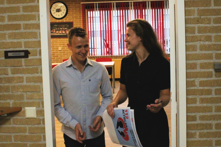 Twee mensen staan in een deuropening en praten enthousiast over 112ActieLab.