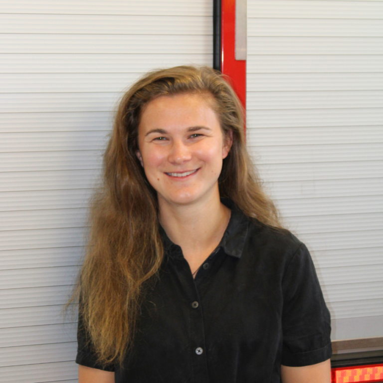 Trainer en medeoprichter 112ActieLab. Draagt een zwarte blouse en lacht.