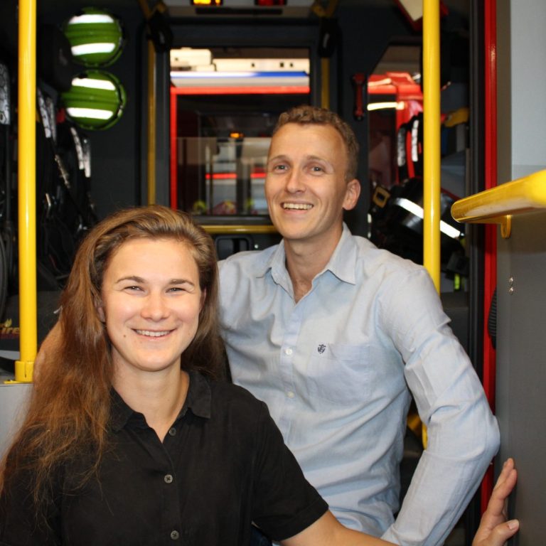 De oprichters van 112ActieLab poserend in een brandweerwagen, lachend en gezellig.