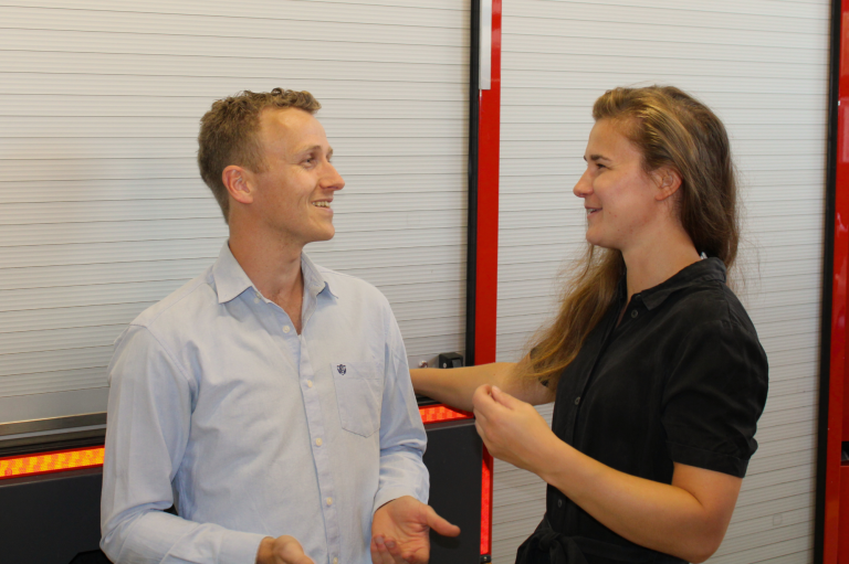 Twee mensen staan tegenover elkaar en lachen tijdens een gesprek over 112ActieLab.